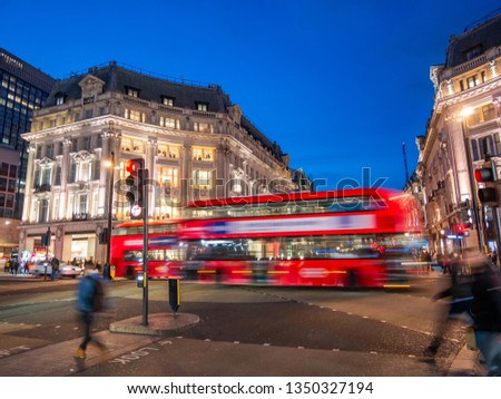 British architecture on Oxford street in the main center of London, with traditional double decker buses in evening lights