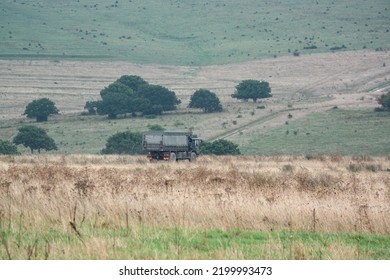 British Army MAN SV HX60 4x4 Logistics Truck Crossing Open Countryside In Action On A Military Exercise