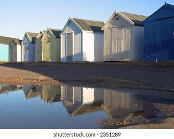 British Beach Huts Relected In Puddle