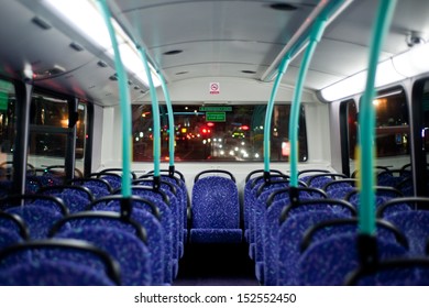 British Bus Interior, Rows Of Empty Blue Seats On A London Double Decker Bus At Night. Covid 19 Coronavirus Lockdown