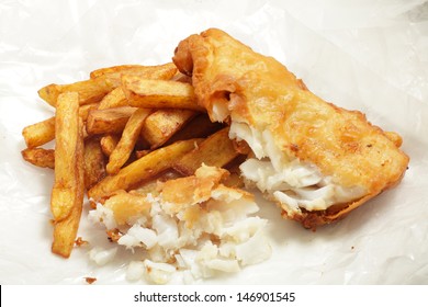 British "chip shop" style fried cod in batter with chips (french fries) in a wrapping of greaseproof paper. Shot with a tilt-shift lens for maximum depth of field.