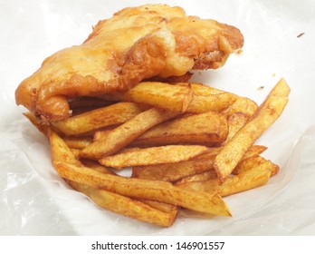 British "chip shop" style fried cod in batter with chips (french fries) in a wrapping of greaseproof paper.