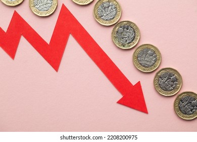 British coins with a red downward arrow. Uk economic crisis - Shutterstock ID 2208200975