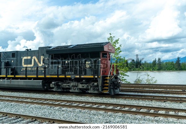 British Columbia,\
Canada - April 30 2021 : Canadian National Railway freight train\
traveling on rural\
area.