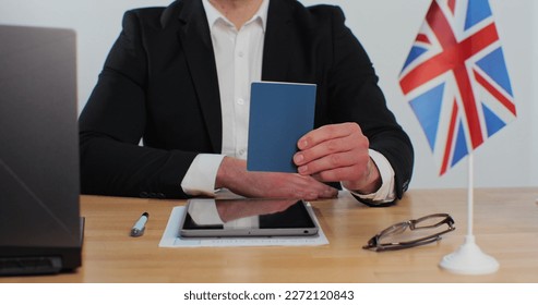British embassy man officer showing passport immigrant, work visa, citizenship. Visa Application online form immigration concept. Visa approval. - Shutterstock ID 2272120843