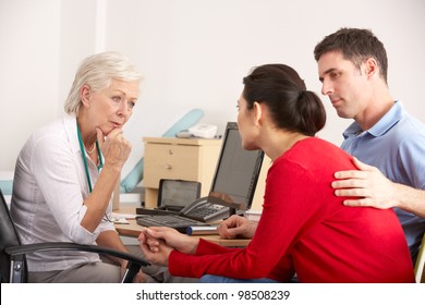 British GP Talking To Anxious Couple In Surgery