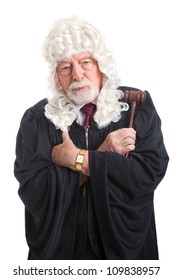 British judge in a wig, with his arms crossed looking stern, serious, and angry.  Isolated on white.