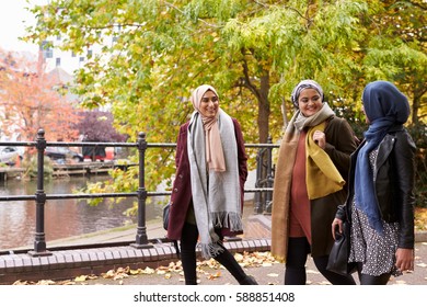 British Muslim Female Friends Walking In Urban Environment