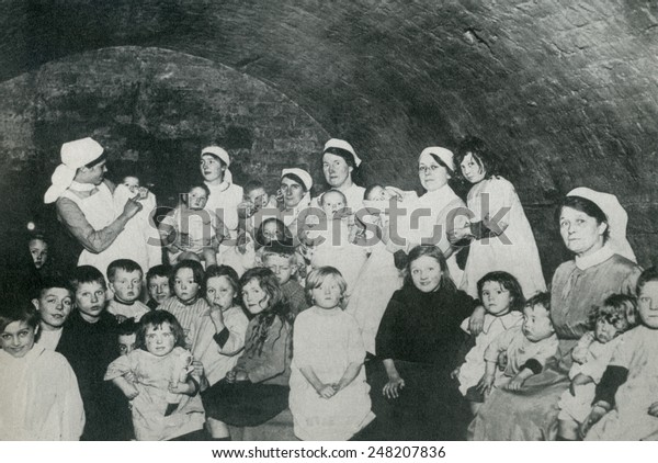 British nannies in a\
basement bomb shelter, probably in London during World War 1. From\
1915-1918, Britain suffered approximately 50 raids with about 550\
deaths and 1350\
injuries.