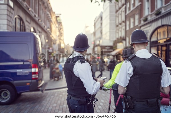 ロンドンの通りを取り締まるヘルメットを着た英国の警察官 の写真素材 今すぐ編集