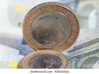 British Pound Coin And Euro Coin On Euro Banknote