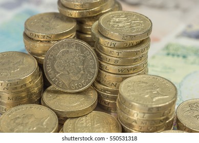 British Pound Coins against a background of British assorted bank notes