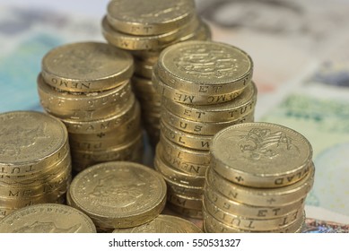 British Pound Coins against a background of British assorted bank notes