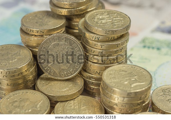 British Pound Coins against a background of British\
assorted bank notes