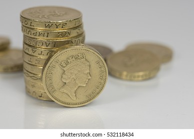 British pound coins up close macro studio shot against a shiny reflective White background

