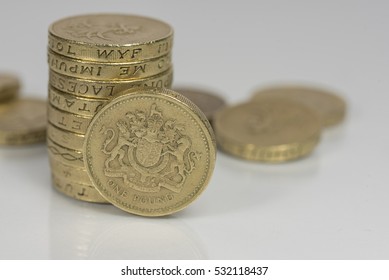 British pound coins up close macro studio shot against a shiny reflective White background

