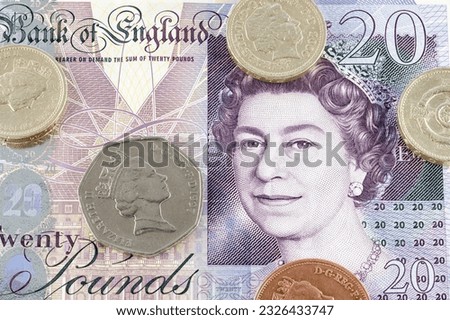 British Pound (GBP) coin Pound notes close up. Coins on a banknote as a financial concept signifying prosperity or recession.