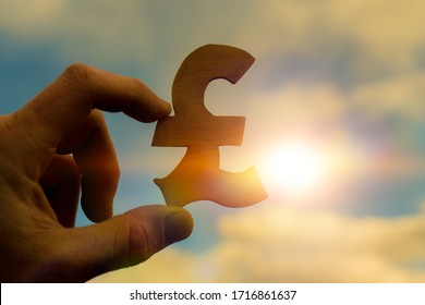 British pound sterling symbol in businessman hand on sunset background, business idea concept, currency, money