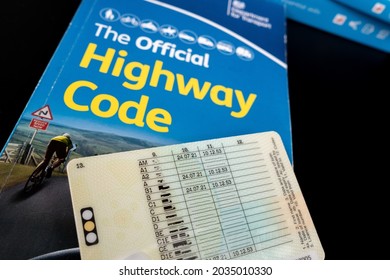 British Provisional Driving Licence on top of The Official Highway Code book. Concept. Stafford, United Kingdom - August 30 2021.