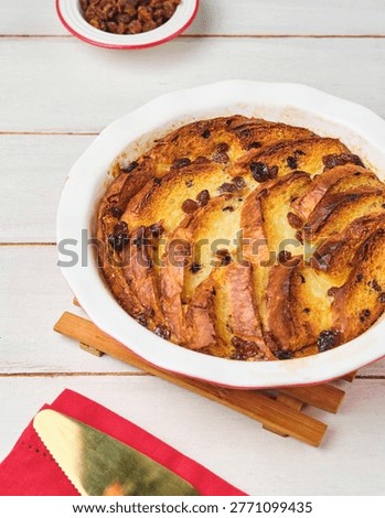 British pudding Bread and butter made from sweet bread with raisins in a round ceramic mold on a white wooden background. English cuisine.