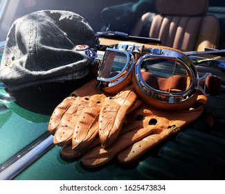 British Racing Cap, Gloves And Goggles On A Green Classic Car