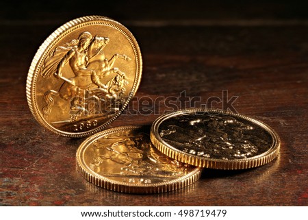British Sovereign gold coins on rustic wooden background