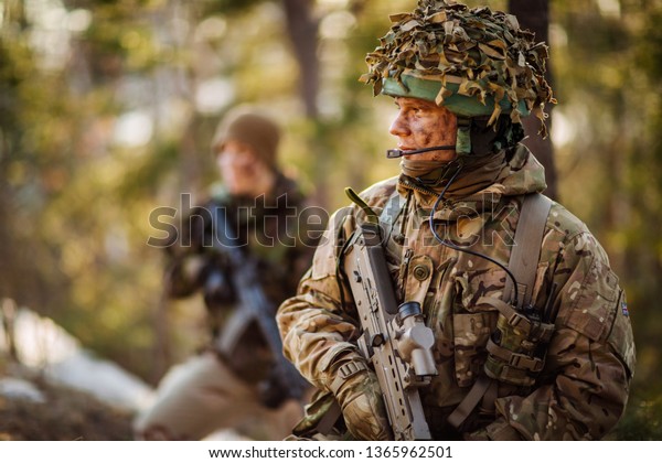 British special\
forces soldier with weapon take part in military maneuver. war,\
army, technology and people\
concept.