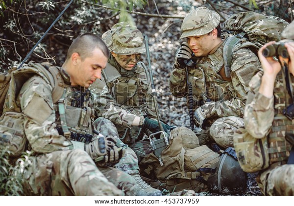 British special forces soldiers\
with weapon and officer holds a radio station, and give orders\
subdivision. war, army, technology and people concept.\
officer