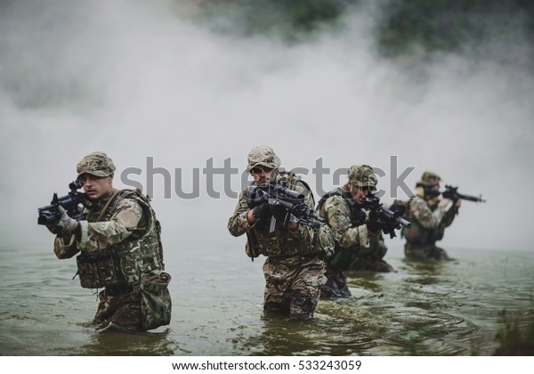 British special\
forces soldiers with weapon take part in military maneuver. war,\
army, technology and people\
concept.