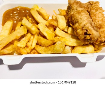 British Style Chips Served With Battered Sausages And Curry Sauce