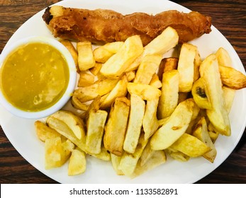 British traditional battered sausage with chips and curry sauce