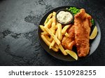 British Traditional Fish and chips with mashed peas, tartar sauce and cold beer.