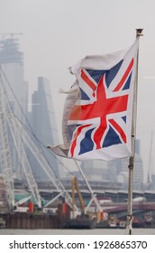 A British Union Flag Or Union Jack Fluttering With Soft Focus London Skyline In The Background