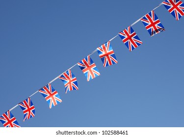 British Union Jack Bunting Flags Against Blue Sky.