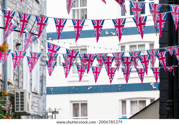 British\
Union Jack flag triangular hanging in preparation for a street\
party. Festive decorations of Union Jack\
bunting.
