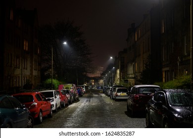 British Urban Empty Streets At Night. Dark Alley Of Edinburgh City With Cars Parking On The Side Of The Road, Damp From The Rain. Downtown Apartment Buildings And Homes Neighborhood, Street Lights On.