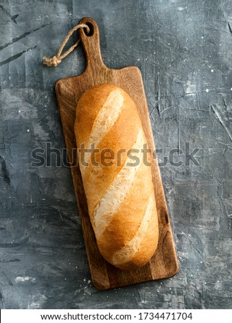 British White Bloomer or European Baton loaf bread on gray background. Top view or flat lay. Copy space for text or design. Vertical.