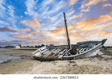 Brittany, Ile d Arz in the Morbihan gulf, a wreck ship on the beach, with the traditional tide mill in background