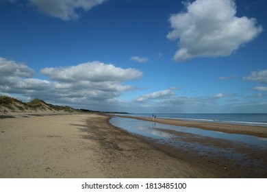 Brittas Bay Beach, County Wicklow, Ireland featuring people on beach under blue sky with clouds