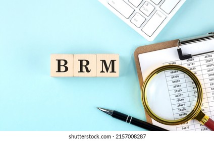 BRM Business Reference Model word on a wooden cubes on blue background with chart and keyboard
