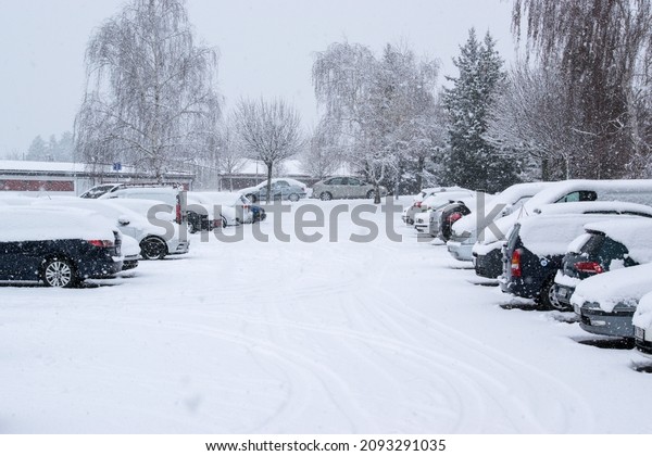 Brno, Czech\
Republic - 12 December 2021: Winter snowy parking lot. Parked cars\
under the snow. Winter in the\
city.
