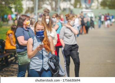 Brno, Czech Republic - April 23 2020: Woman With A Cloth Face Mask Waiting In Long Line Of People For A Test As Part Of A Study On Collective Immunity Against The Corona Virus.