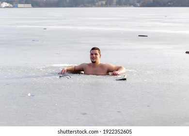 Brno Czech Republic February 18 2021 A young man hardening in icy water in a cut round hole on the frozen surface of a lake
