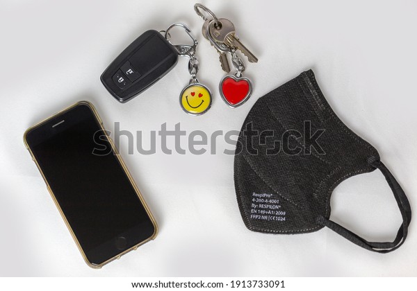 Brno Czech Republic February 6 2021 - Mobile\
phone, black face mask, car keys with a yellow pendant, apartment\
keys with a red heart.