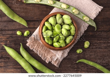 Broad bean or fava beans (Fave) on the rustic wooden background, close-up. From garden to table: springtime vegetables and legumes for spring recipes