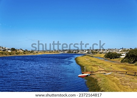 Broad Goukou river estuary with small jetty and boat flowing through the town of Still Bay in the Western Cape, South Africa