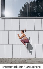 Broad Jump. Young Slim Sportive Caucasian Woman Training, Exercising On City Street. Concept Of Healthy Lifestyle, Physical Activity, Well-being.