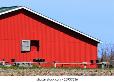 Broad Side Of A Red Barn With A Window.