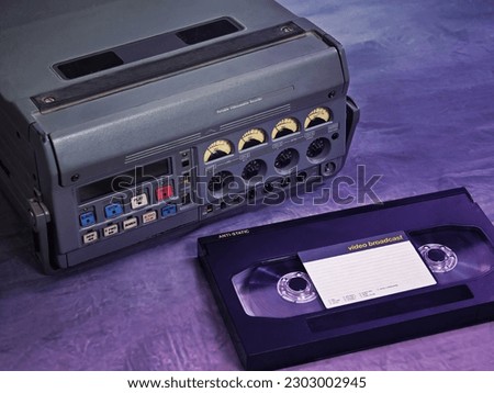 Broadcast professional video player, recorder and a cassette. Vintage TV equipment with a purple, retro aesthetic