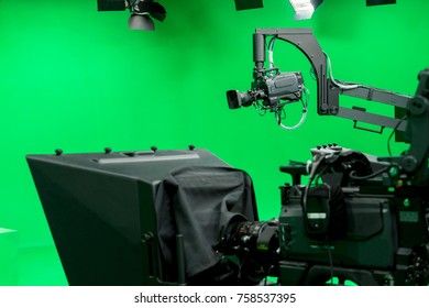 Broadcast Television Studio Camera In Greenscreen Studio Room With LED Lights On The Ceiling.